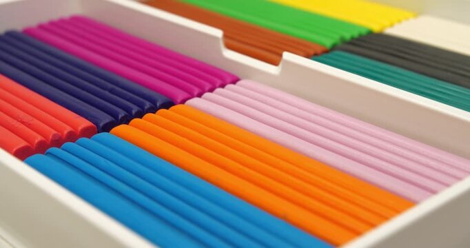 Colorful pieces of plasticine in a box. Soft modeling clay blocks for creative fun. Plasticine pieces ready for fun and creativity. Fun clay blocks for skillful modeling