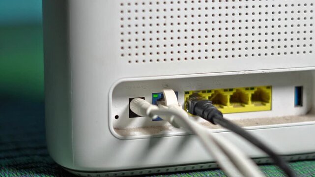 Close Up of Ethernet Cables Plugged into Wireless Wifi Router Ports. Networking Modem with Connected LAN Cables in Smart Office Setup. 