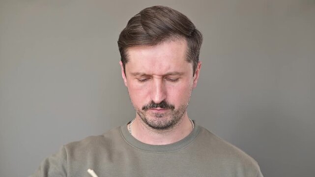 A man sniffs a container of sushi rolls and winces at the unpleasant odor. A young woman tastes the spoiled food and spits it back out