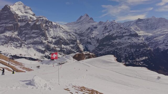 Swiss flag on a mountain top, symbol of neutrality and beauty in the Bernese Oberland.