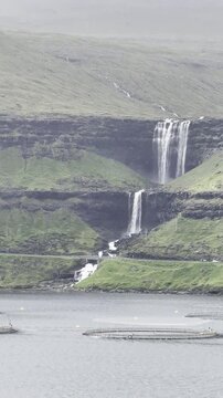 Green nordic landscapes of the Faroe Islands. A popular two-tier Fossa waterfall, Streymoy island.