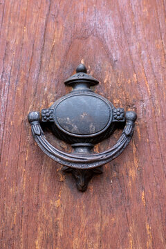 Antique iron door knocker on a rustic weathered wooden door