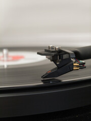 Close up of turntable needle playing vinyl record. Concept of analog music and retro audio technology.