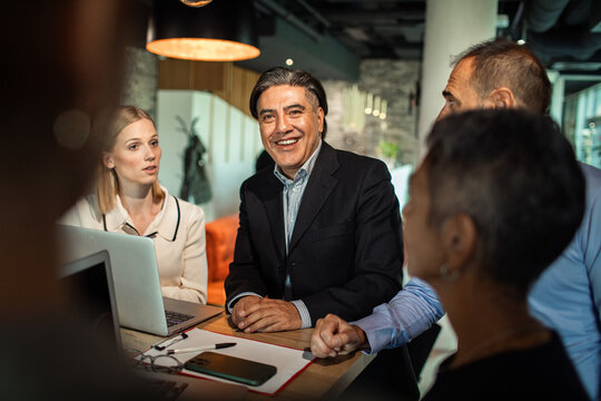 Smiling manager leading team discussion in modern office