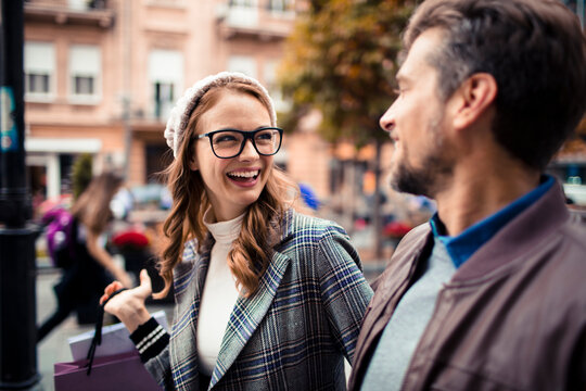 Young couple smiling while shopping in city