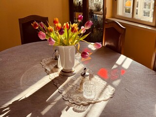 Interior of an old house in Eastern Europe. A vase of flowers on a table in the dining room of a...