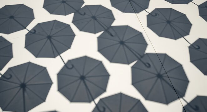 Multiple Dark Gray Umbrellas Shadows Pattern on White Background