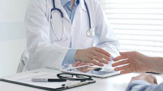 Doctor shaking hands with her patient in the office after a successful medical examination, healthcare and trust concept. Medicine and health care
