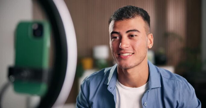 Phone, ring light and influencer with welcome for live stream, content creation and social media in home. Man, streamer and gen z person with tech for broadcast, performance and online introduction