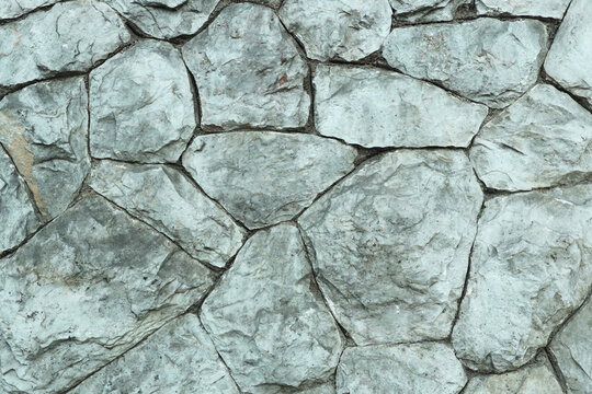 Gray grey stone wall aged rocks stacked stones architecture. Creative building concept
