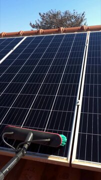 A practical and eco-friendly scene showing solar panels being cleaned during the spring season. 