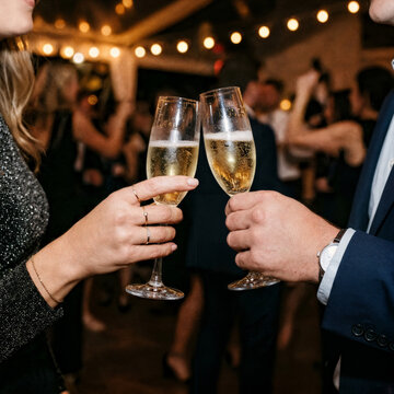 Two hands with glasses of champagne cheering, celebrating new year's eve, toast, cheering, wedding and birthday, special event, celebrating together, party, anniversary, sparkling wine