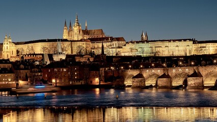 Obraz premium Prague Castle and Charles Bridge illuminated over Vltava River at night