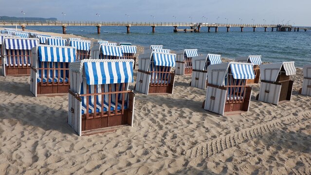 Strandkorb on Rugen beach with blue striped canopies lined along sandy shore