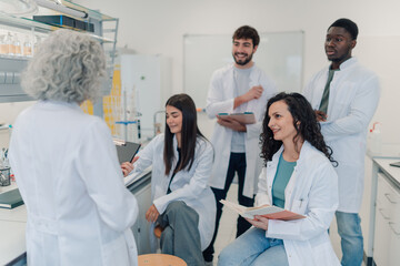Diverse students collaborating with professor in laboratory