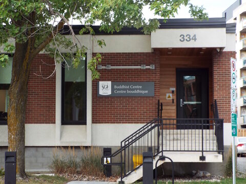 Ottawa, Ontario, Canada-July 22, 2025: The "SGI Canada Buddhist Centre" features a brick exterior, modern signage in English and French, and a black-railed staircase entrance at 334 Churchill Ave N.