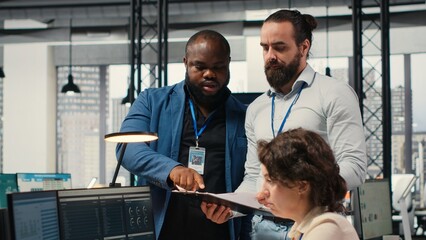 Diverse corporate staff working together on report writing in the office, collaborating on building...