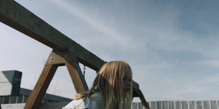 Young boy holding a paper airplane outdoors, he throws it and runs to collect it