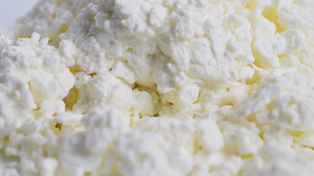 Fresh dairy closeup, Creamy cottage cheese macro shot, Detailed image of moist curds in natural light, Highresolution macro photograph of fresh cottage cheese curds