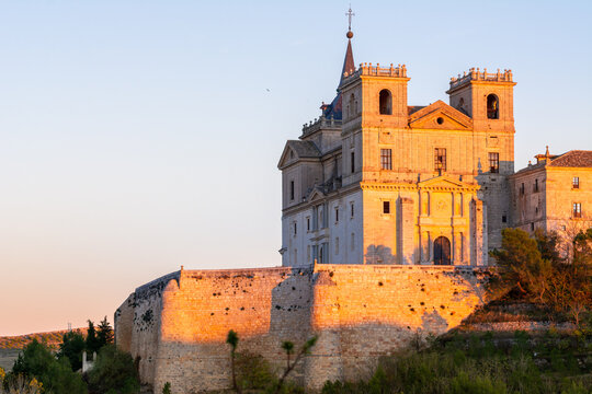 Golden hour sunlight illuminating the historic Monastery of Ucl&eacute;s above the countryside landscape in Cuenca province, Castilla-La Mancha, Spain.