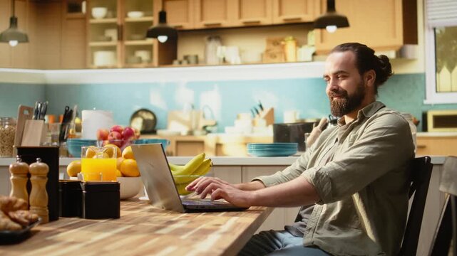 Remote worker, kitchen table with laptop, online work and tasks, professional lifestyle of connected male using technology and data tools for productivity. Teleworking from rustic home.