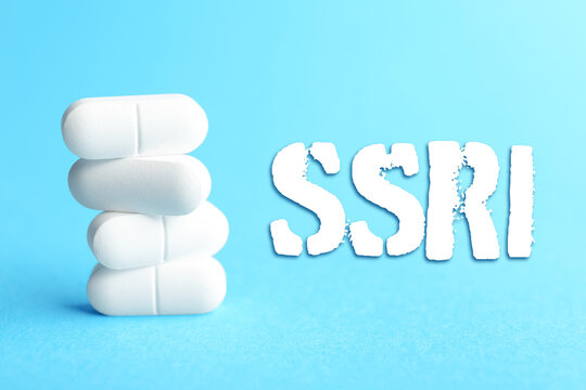 SSRI and white pills on light blue background. Selective serotonin reuptake inhibitor, antidepressants