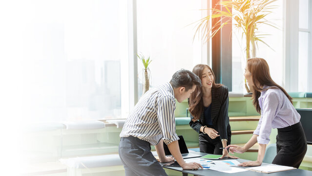 A group of Gen Z Asian business consulting, exchanging information in offices, co-working spaces.