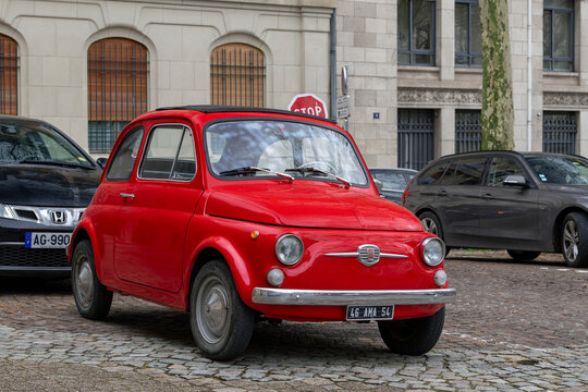 Nancy, France - March 14th 2026 : View on a red Fiat 500 parked on a street. The Fiat 500 is a city car that was manufactured and marketed by Fiat Automobiles from 1957 until 1975.