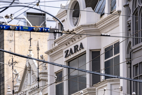 ZARA retail store signage on a historic building facade in Melbourne, Australia, with tram wires crossing the frame.  Zara is a Spanish fast fashion retailer and a subsidiary of Inditex.