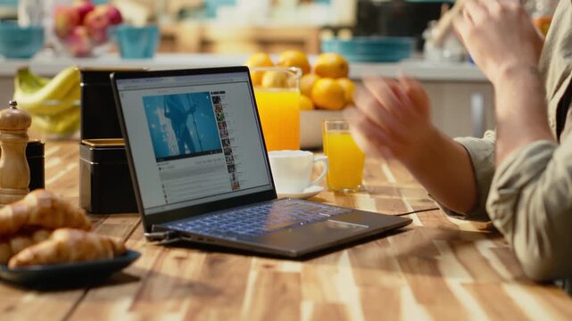 Male watching online video recorded content on laptop at home, streaming platform for free to watch digital clips. Relaxed lifestyle moment with entertainment, modern everyday life indoors.