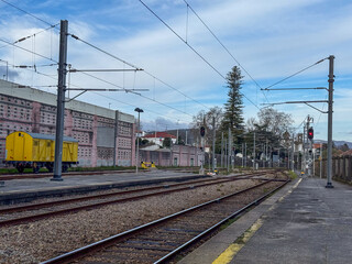 Fototapeta premium empty railway station platform with tracks and yellow wagon concept of transport, logistics, travel, banner