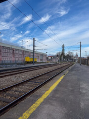 Obraz premium empty train station platform, tracks, blue sky, concept of transport, travel, logistics, banner