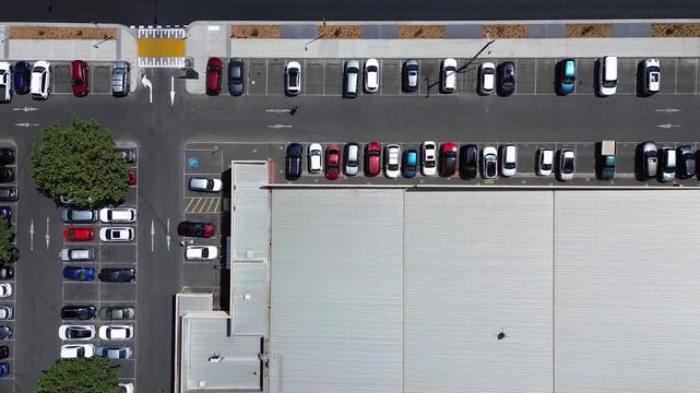 Top down aerial view of parking lot with cars and urban street layout