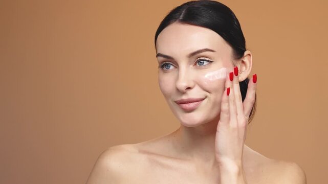 Young woman using serum dropper on face isolated on background. Anti-aging and skincare concept.
