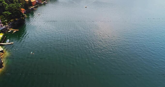 Drone alternating glitches, glitch clearing revealing motorboat leaving wake, surveying shoreline