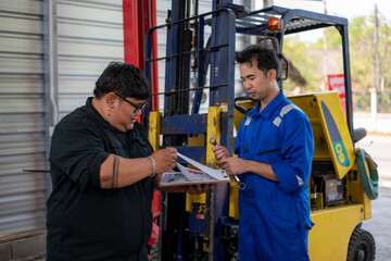 Mechanic team inspecting forklift for maintenance and repair © Wasana