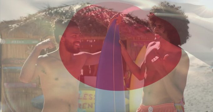 Two men reaching surfboard, gesturing on beach, red orb and flag overlay rippling, planning surfing