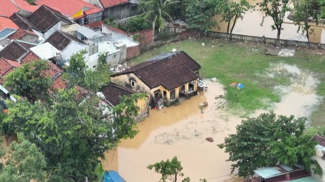Flooding in Hoi An, Vietnam, shows homes and businesses inundated with floodwater. The flood is due to heavy rains and storms in the region, causing damage to property.