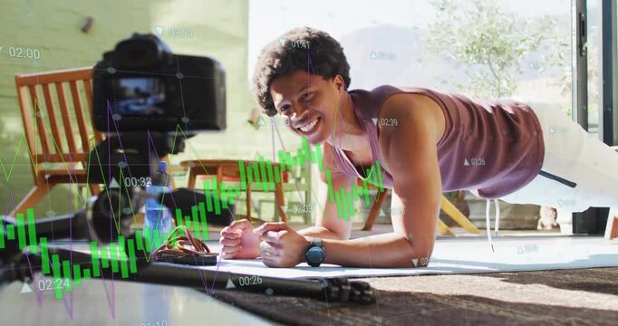 Trainer holding forearm plank mat, tripod filming addressing camera, green waveform aligning torso