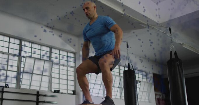 Man shifting weight, jumping onto plyo box for fitness, landing, dotted trail marking jump path
