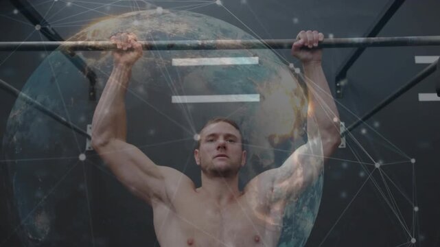 Man gripping pull-up bar, pulling up in fitness gym while globe overlay drifting over him, training