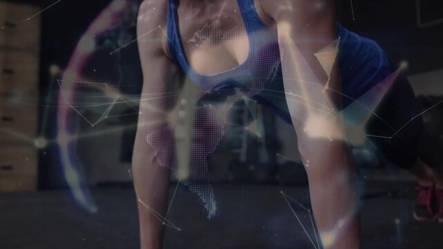 Mid adult woman doing pushups on black floor, breathing and activating lines and globe for fitness
