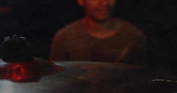 Male drummer following beat raising stick striking cymbal leaning and checking kit for music set
