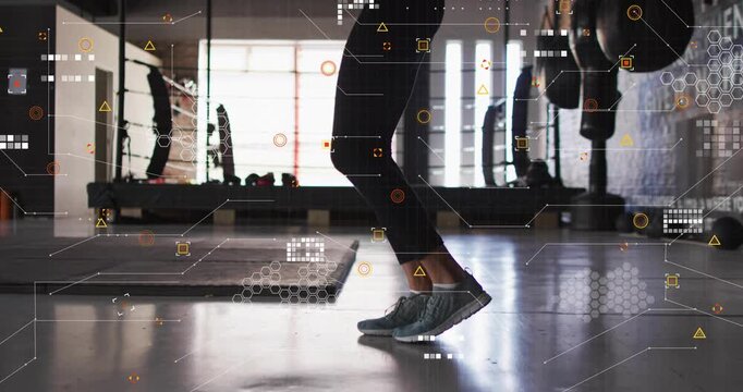 Female fitness participant warming up for workout, hopping and alternating knee lifts on gym floor