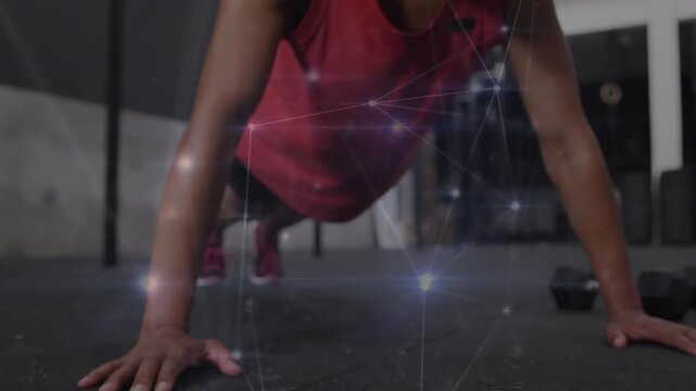 Woman doing pushups at gym, breath starting descent, overlay showing muscle for fitness