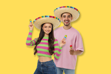 Fototapeta premium Cinco de Mayo, Young couple in bright sombreros with maracas