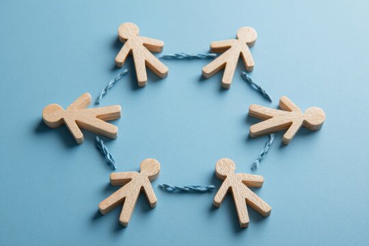 Circle of Unity:  A visual depiction of collaboration and teamwork. Wooden figurines linked together, forming a circle symbolizing unity and interconnectedness.