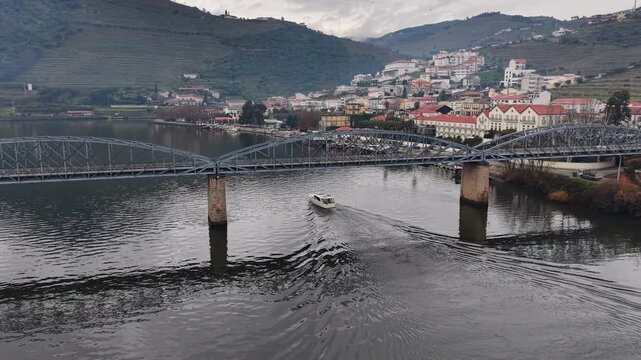 Boat passing under bridge in Pinhao on Douro River, Portugal