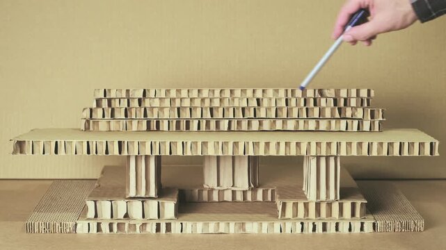 Man Building Architectural Model from Layered Honeycomb Cardboard Panels