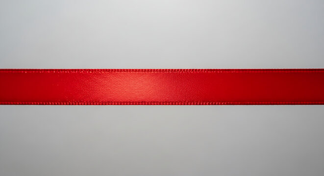 Vibrant red satin ribbon texture on white minimalist background